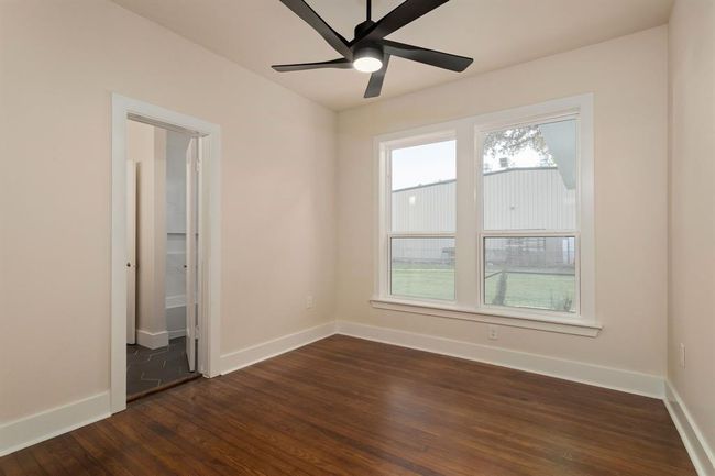 In this secondary bedroom, you'll appreciate the restored original hardwood floors, large windows, high ceiling with modern fan & light kit, and direct access to the hollywood bathroom. | Image 23