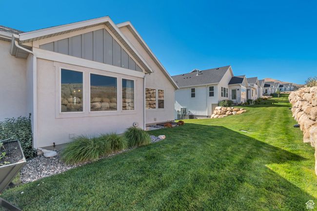 Back of property with a lawn, board and batten siding, a residential view, and stucco siding | Image 6