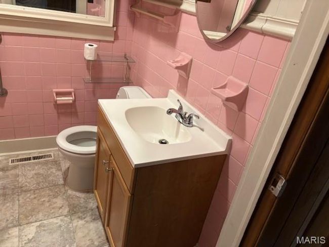 Half bath with toilet, tile walls, and vanity | Image 30