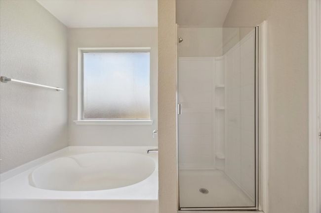 Bathroom with a stall shower and a bath | Image 12