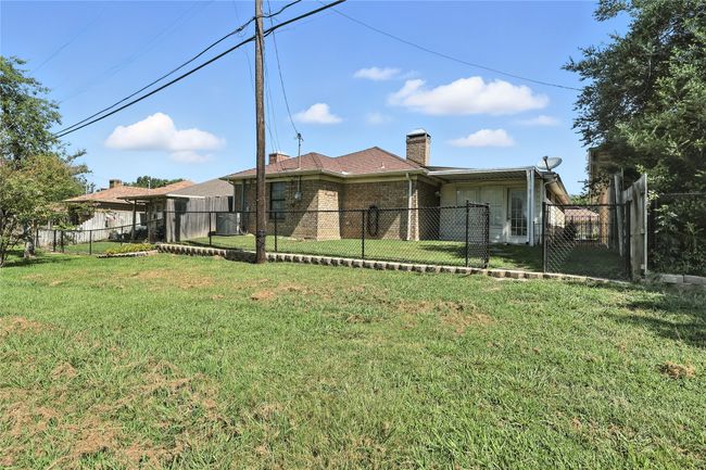 Back of house with a chimney, brick siding, and a fenced backyard | Image 10