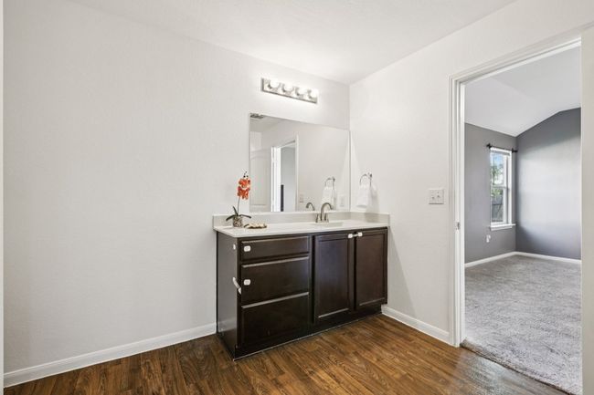 Bathroom featuring double vanity, wood finished floors, and vaulted ceiling | Image 21