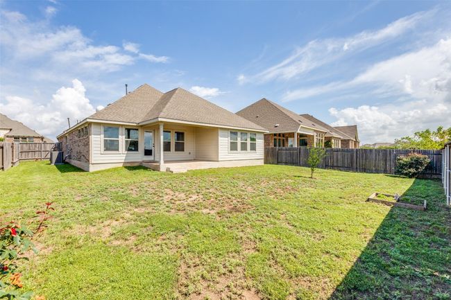 Rear view of house featuring a patio, a fenced backyard, and roof with shingles | Image 25