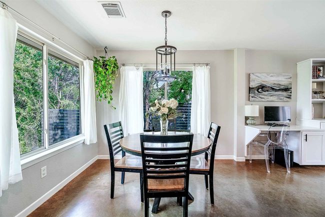 Dining area with baseboards, visible vents, and finished concrete floors | Image 5