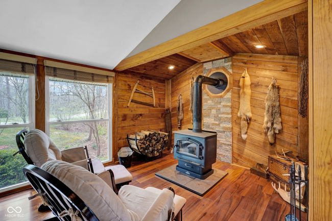 living area with vaulted ceiling, wood walls, and a healthy amount of sunlight | Image 12