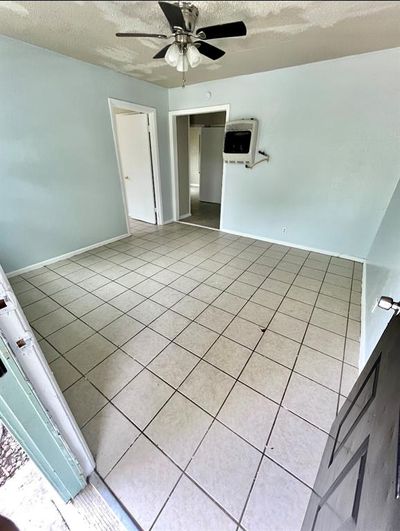 Tiled spare room with heating unit, ceiling fan, and a textured ceiling | Image 3