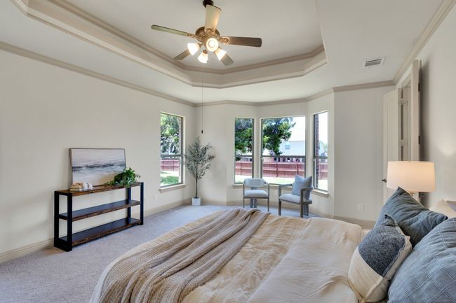 Bedroom featuring a raised ceiling, carpet flooring, crown molding, and a ceiling fan | Image 13