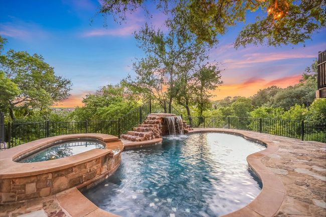 View of pool featuring a waterfall with connected hot tub/spa flanked by a canyon and distant views. | Image 34