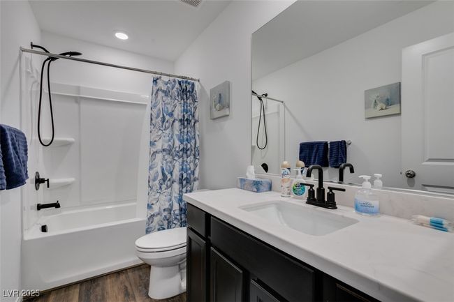 Full bathroom with shower / bath combination with curtain, toilet, vanity, and wood finished floors | Image 16