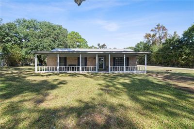 View of front facade featuring a front lawn and a porch | Image 1