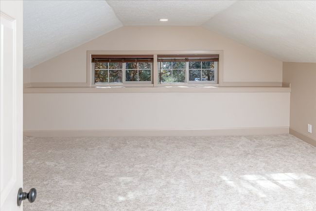 Additional living space with a textured ceiling, carpet, and lofted ceiling | Image 37