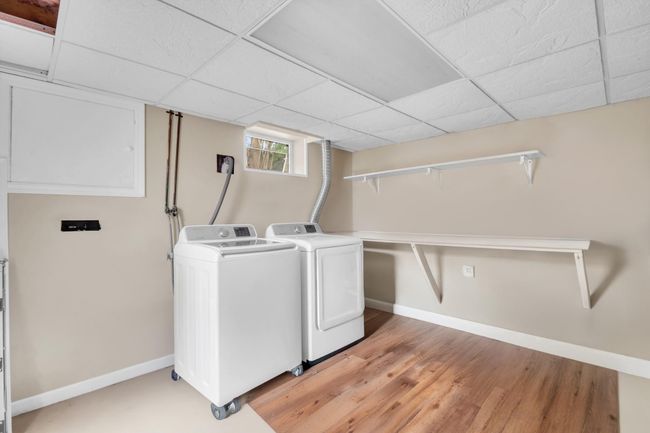 Laundry area featuring washer and dryer, baseboards, laundry area, and light wood-type flooring | Image 21