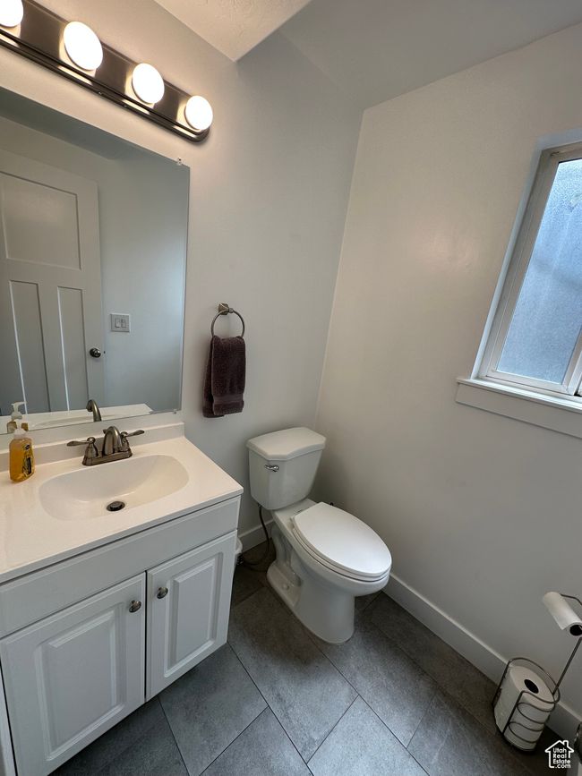 Bathroom with baseboards, toilet, vanity, and tile patterned floors | Image 27