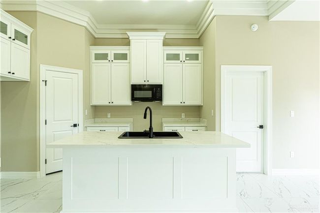 Kitchen featuring black microwave, marble finish floor, a sink, and baseboards | Image 19