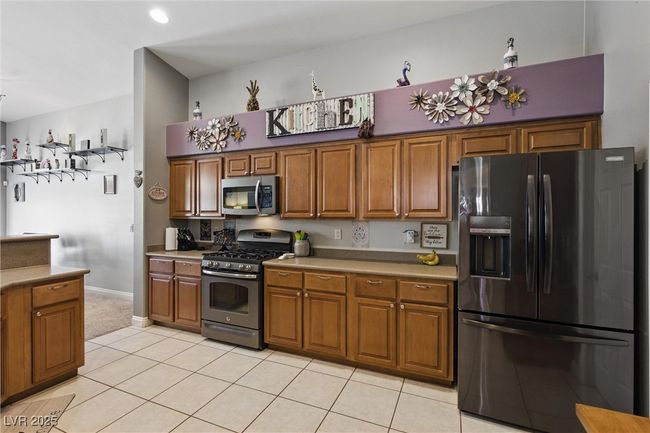Kitchen featuring stainless steel appliances, brown cabinets, and light tile patterned flooring | Image 6