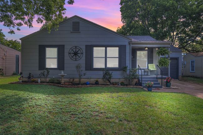 View of front facade with an attached garage, a front lawn, concrete driveway, and a porch | Image 21