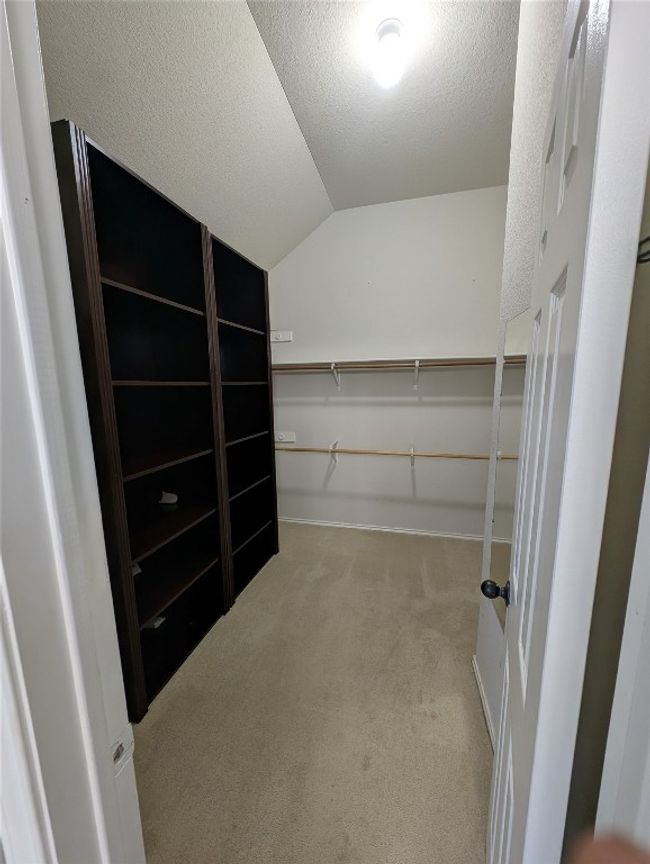 Walk in closet with vaulted ceiling and carpet flooring | Image 13