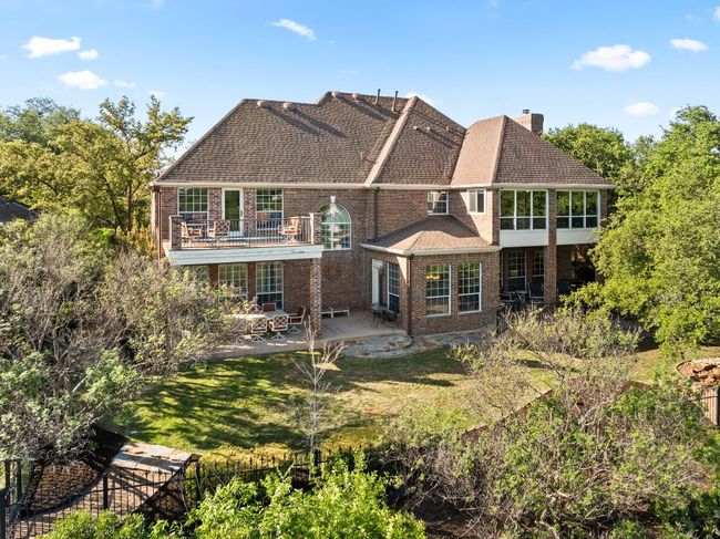 Back of house showing two covered patios, an uncovered deck upstairs, a gate to the greenbelt - all on .30 of an acre. | Image 30