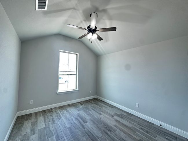 Additional living space featuring ceiling fan, dark wood finished floors, vaulted ceiling, and baseboards | Image 19