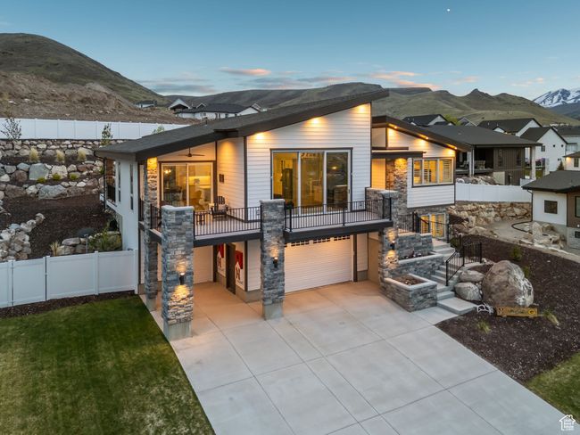Rear view of house with fence, a garage, a mountain view, concrete driveway, and a lawn | Image 68