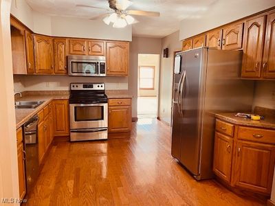 Kitchen with stainless steel appliances, ceiling fan, wood-type flooring, and sink | Image 3