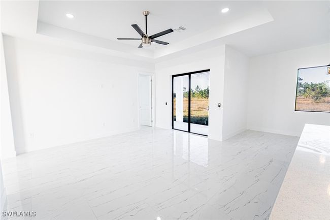Unfurnished room with a raised ceiling and ceiling fan | Image 6