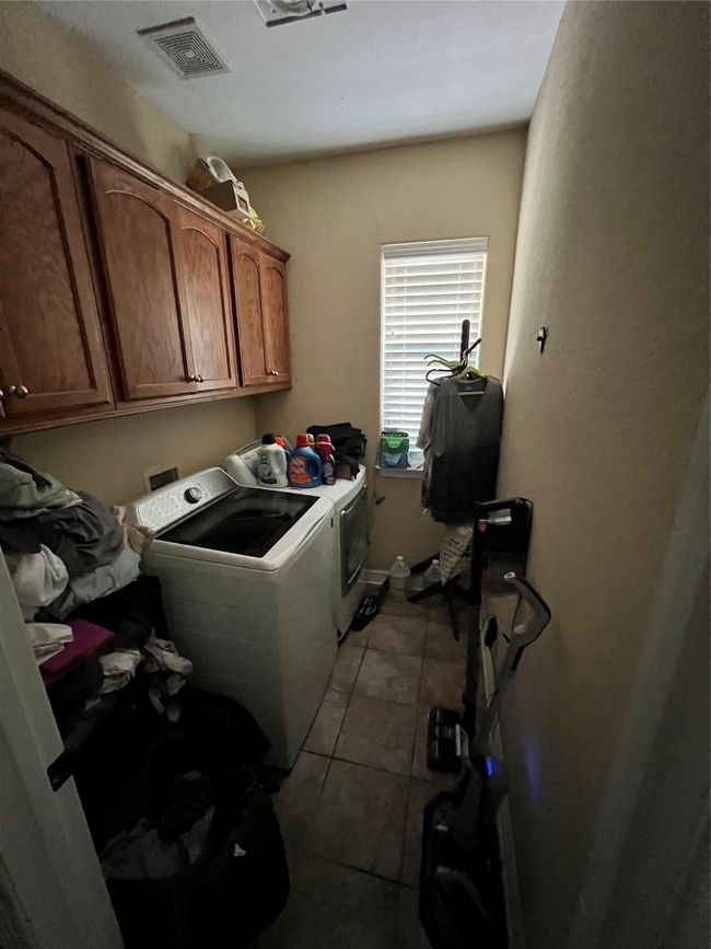 Laundry area featuring cabinet space, independent washer and dryer, and tile patterned floors | Image 13