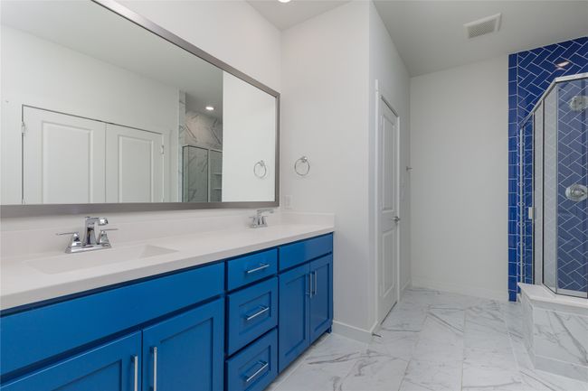 Bathroom with double vanity, a shower stall, and marble finish flooring | Image 17