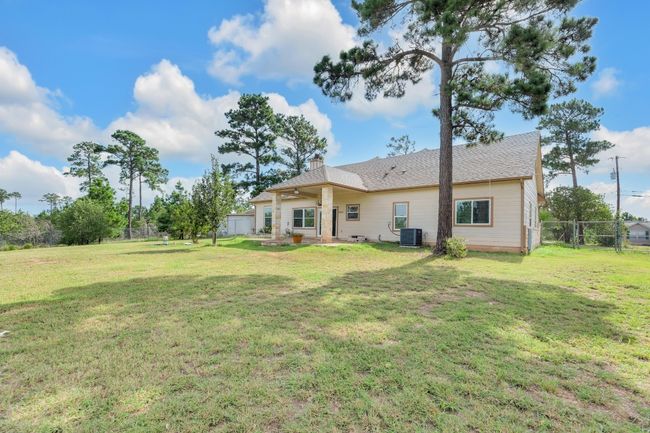 Back of property featuring a chimney, a patio area, a shingled roof, and a ceiling fan | Image 36