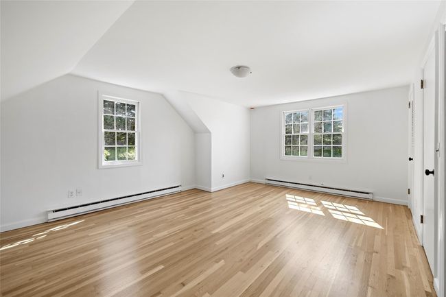 Bonus room featuring a healthy amount of sunlight, a baseboard radiator, baseboard heating, and light wood-style flooring | Image 17