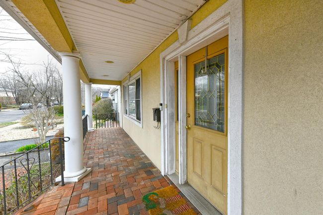 Doorway to property featuring stucco siding and a porch | Image 12