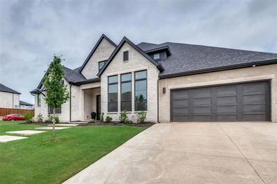 View of front facade with a front yard and a garage | Image 2