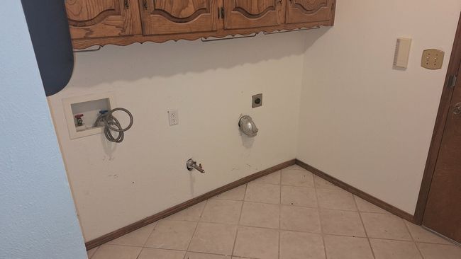 Laundry room with cabinet space, washer hookup, electric dryer hookup, and light tile patterned floors | Image 15