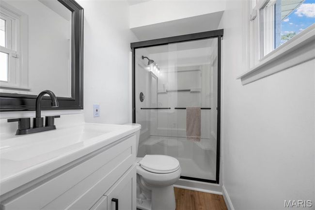 Bathroom featuring a stall shower, vanity, and wood finished floors | Image 20
