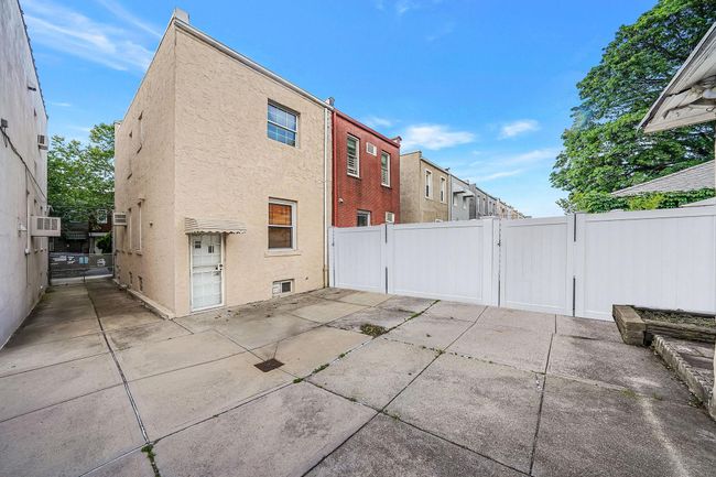 Rear view of house featuring a gate, stucco siding, a patio area, and cooling unit | Image 29