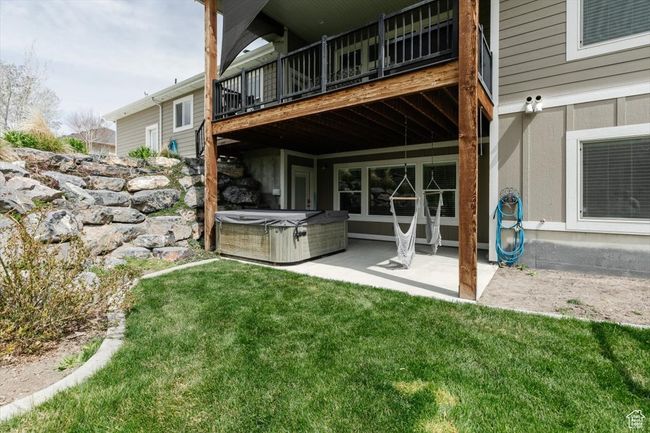 Rear view of property featuring a lawn, a hot tub, and a patio | Image 67