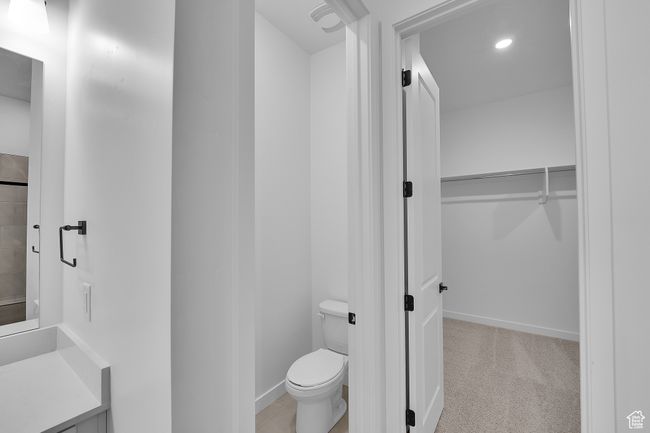 Bathroom with toilet, a spacious closet, vanity, and recessed lighting | Image 17