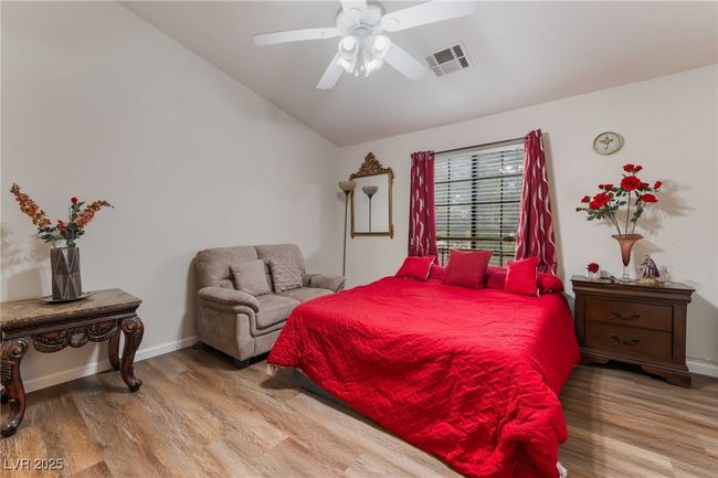 Bedroom with wood finished floors, visible vents, vaulted ceiling, and baseboards | Image 27