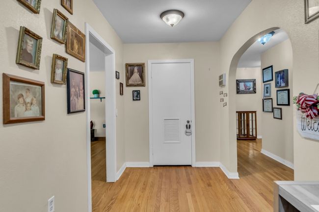 Foyer entrance with arched walkways and light wood-style floors | Image 5