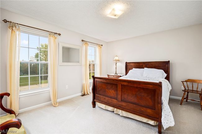Carpeted bedroom with multiple windows and a textured ceiling | Image 26
