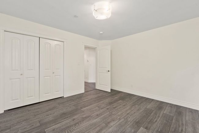Unfurnished bedroom featuring dark wood-style floors and a closet | Image 21