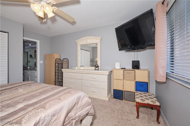 Bedroom with carpet floors, a ceiling fan, and connected bathroom | Image 21