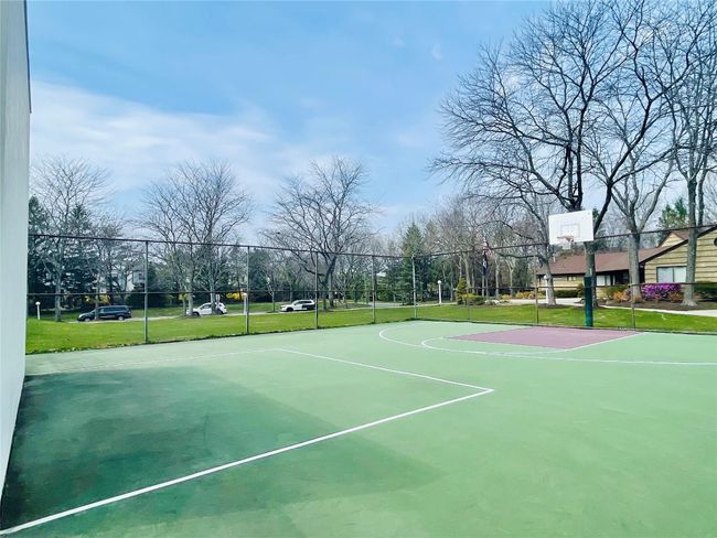 View of sport court featuring a lawn, community basketball court, and fence | Image 26
