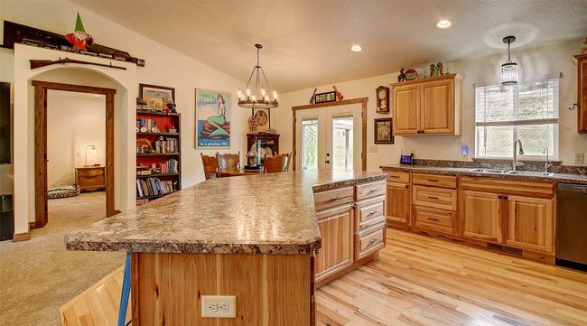 Kitchen with a sink, dishwasher, lofted ceiling, decorative light fixtures, and a kitchen island | Image 8