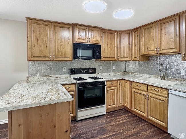 Kitchen with black microwave, gas stove, dishwasher, a sink, and decorative backsplash | Image 4
