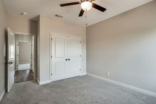 Unfurnished bedroom with visible vents, a ceiling fan, carpet floors, a closet, and baseboards | Image 19