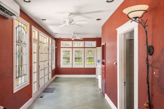 Unfurnished sunroom featuring french doors and a wall unit AC | Image 14