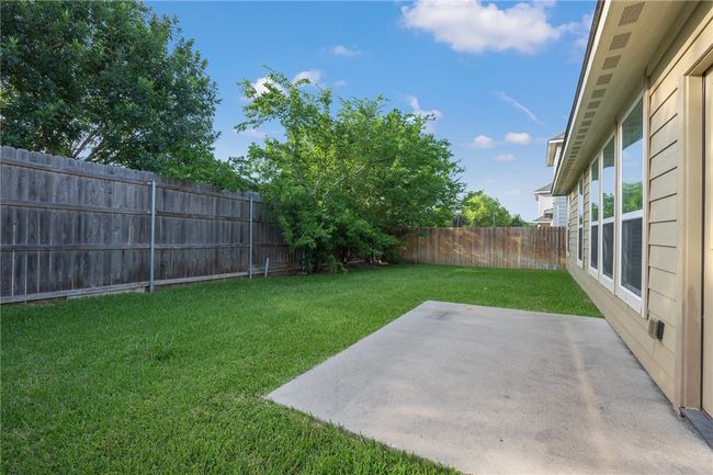 Fenced backyard with a patio area | Image 26