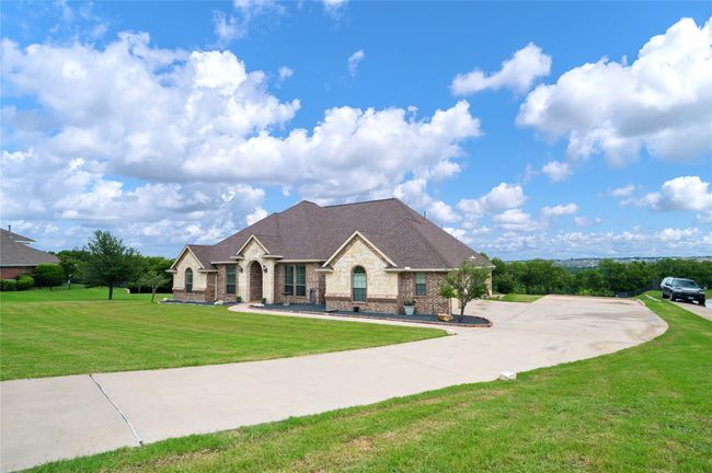 French provincial home with a front yard, brick siding, and roof with shingles | Image 34