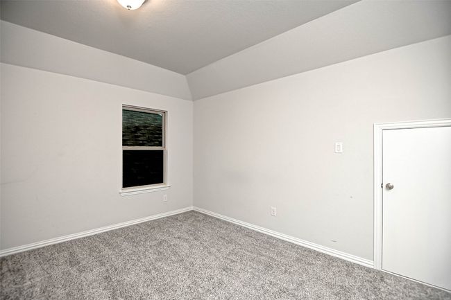 Carpeted empty room featuring baseboards and lofted ceiling | Image 30